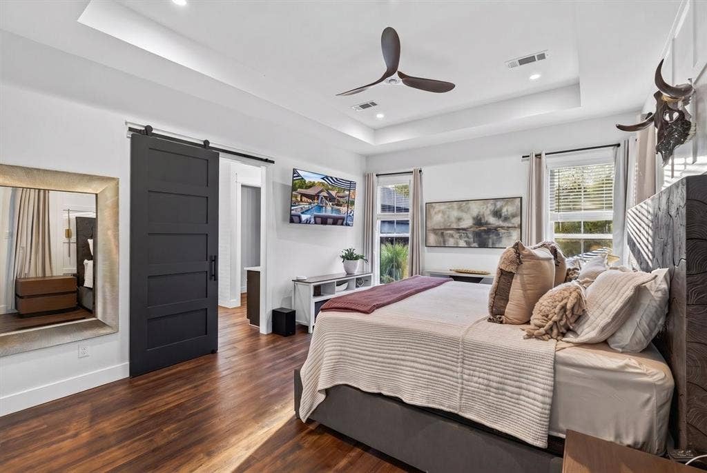 104 Oakbend Trail, Mabank, TX 75147 Primary bedroom with tray ceiling, modern ceiling fan, large windows, and a door directly out to the patio! Main Residence.