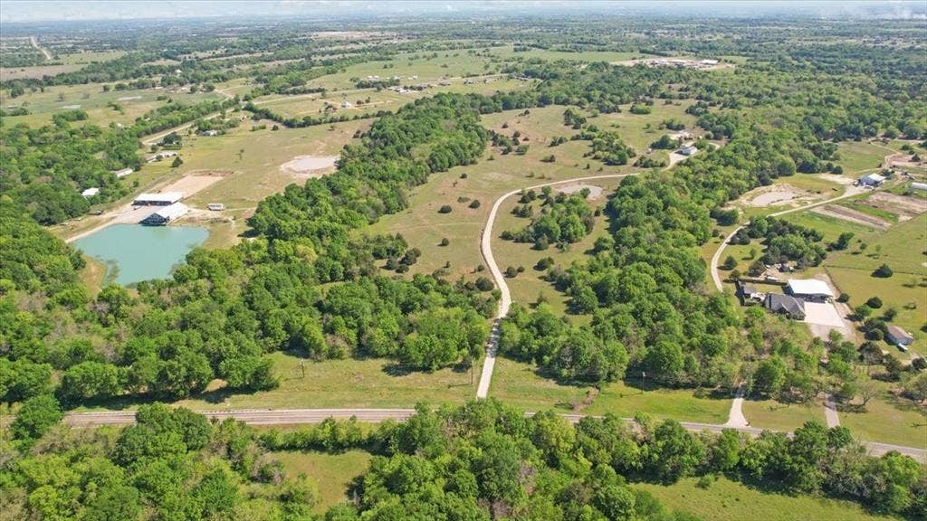 2377 FM 36 N, Farmersville, TX 75442 Expansive acreage featuring mature tree lines, open pastures, a private pond, and a winding gravel driveway