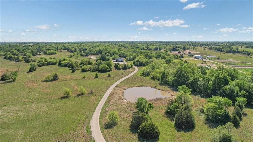 2377 FM 36 N, Farmersville, TX 75442 Expansive acreage featuring mature trees, open pasture, a private pond, and a gravel drive