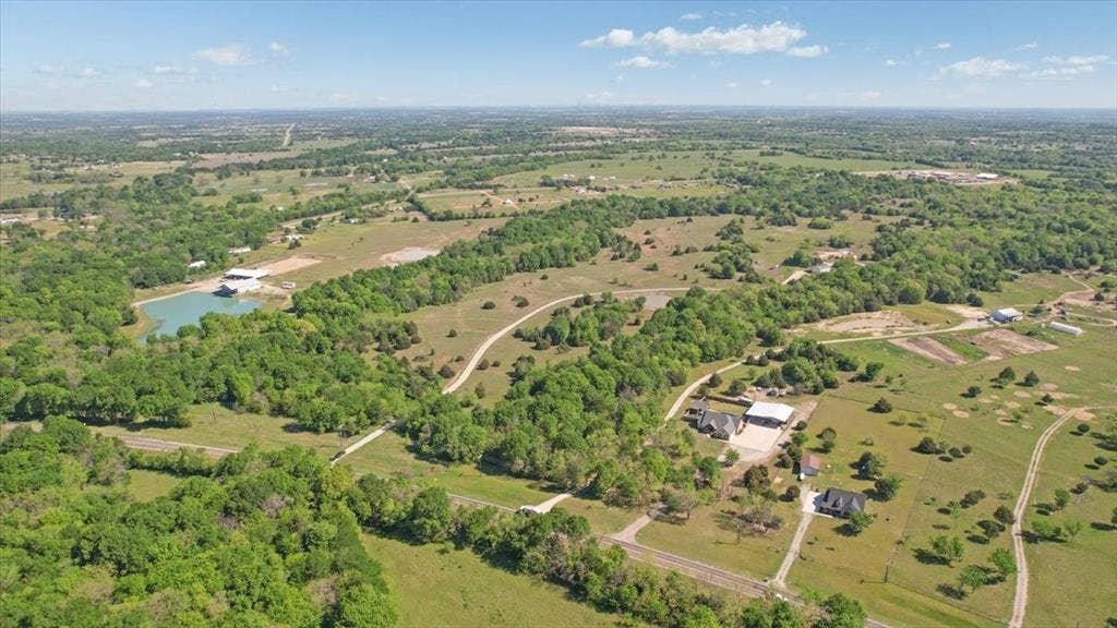 2377 FM 36 N, Farmersville, TX 75442 Aerial perspective of rural acreage featuring rolling landscape, mature trees, open pasture, and a private pond