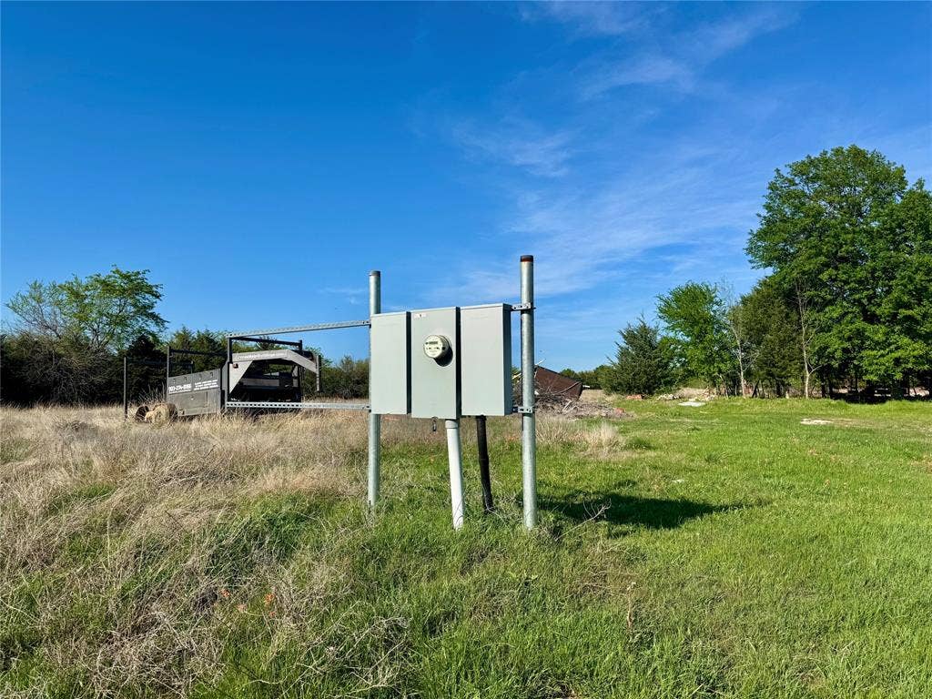 2377 FM 36 N, Farmersville, TX 75442 Electrical service meter and breaker box mounted on a metal post structure set within an open landscape