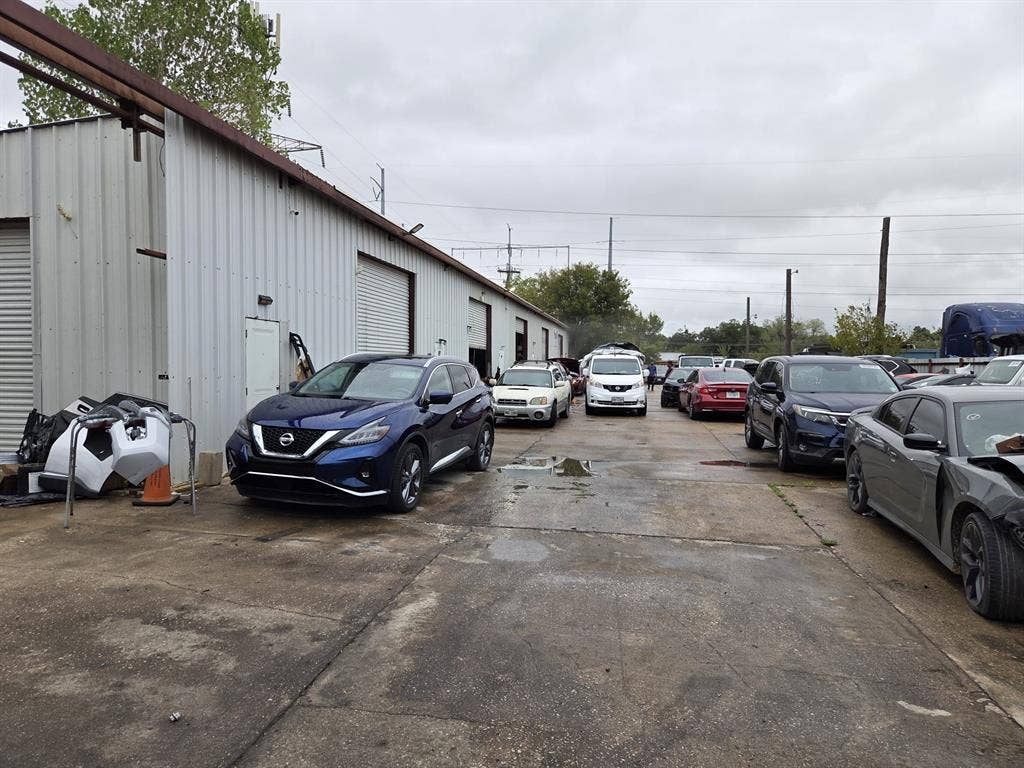 2319 Cartwright Street, Dallas, TX 75212 Industrial building featuring a corrugated metal exterior, multiple roll-up doors, and an expansive concrete parking area