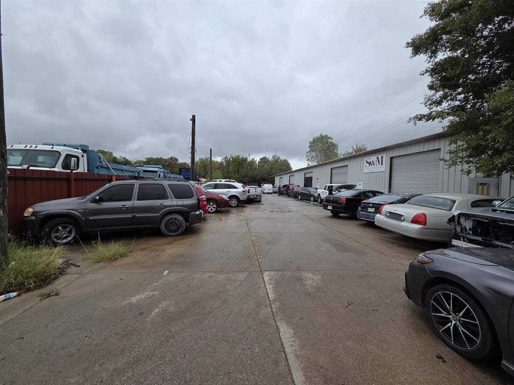 2319 Cartwright Street, Dallas, TX 75212 Industrial warehouse facility featuring metal exterior siding, multiple roll-up doors, and expansive concrete paved frontage