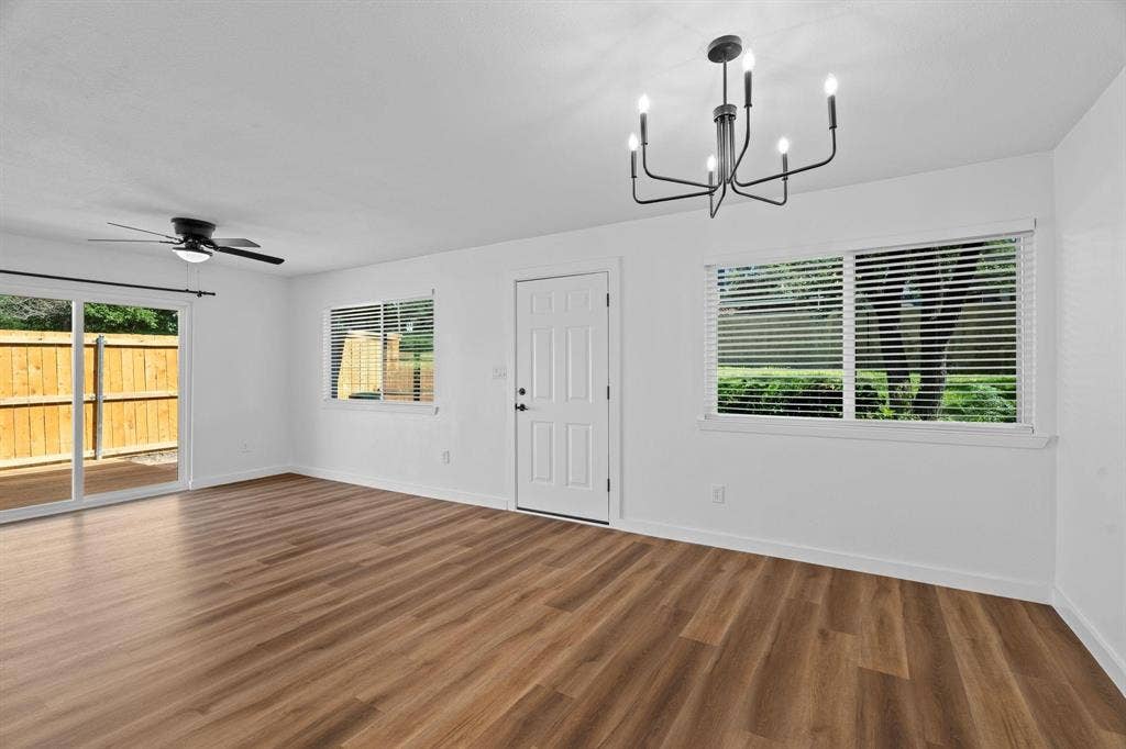 2621 Amherst Court, Irving, TX 75038 Living space featuring wood-finish flooring, a contemporary six-arm chandelier, ceiling fan, and sliding glass door access to the exterior