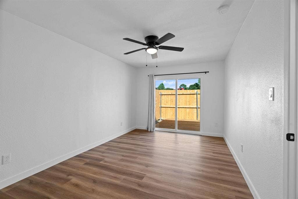 2621 Amherst Court, Irving, TX 75038 Interior space featuring wood-finish flooring, white walls, a ceiling fan with integrated lighting, and a sliding glass door providing external access