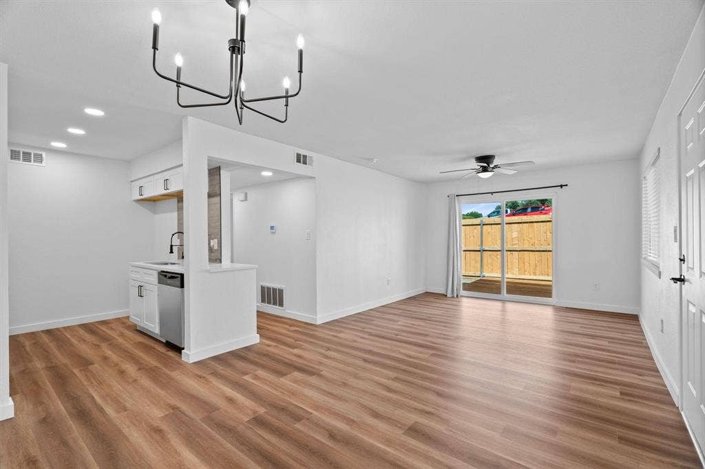 2621 Amherst Court, Irving, TX 75038 Open-concept area featuring wood-finish flooring, a contemporary six-arm chandelier, recessed lighting, a ceiling fan, and sliding glass doors