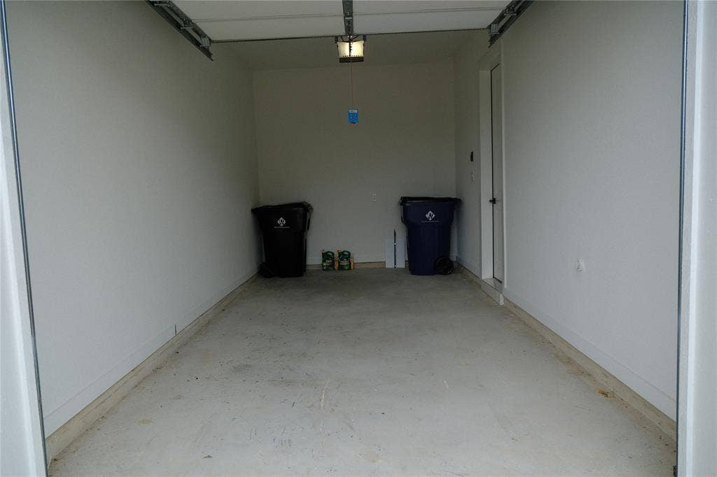 10694 Hollydale Lane, Frisco, TX 75035 Attached second garage featuring concrete flooring, crisp white walls, and a dedicated entry door