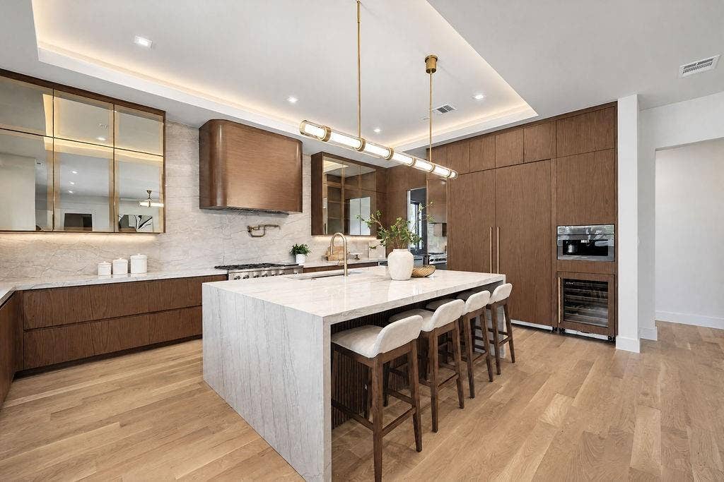 Pour drinks for friends at the island bar while preparing dinner across wide quartzite countertops