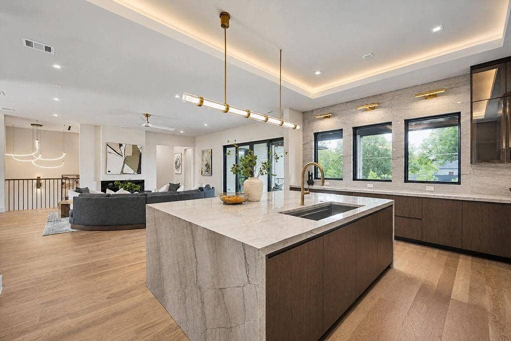 Feel the joy of cooking in a bright, open kitchen fitted with double wall ovens, cove lighting, and plenty of room for extra hands