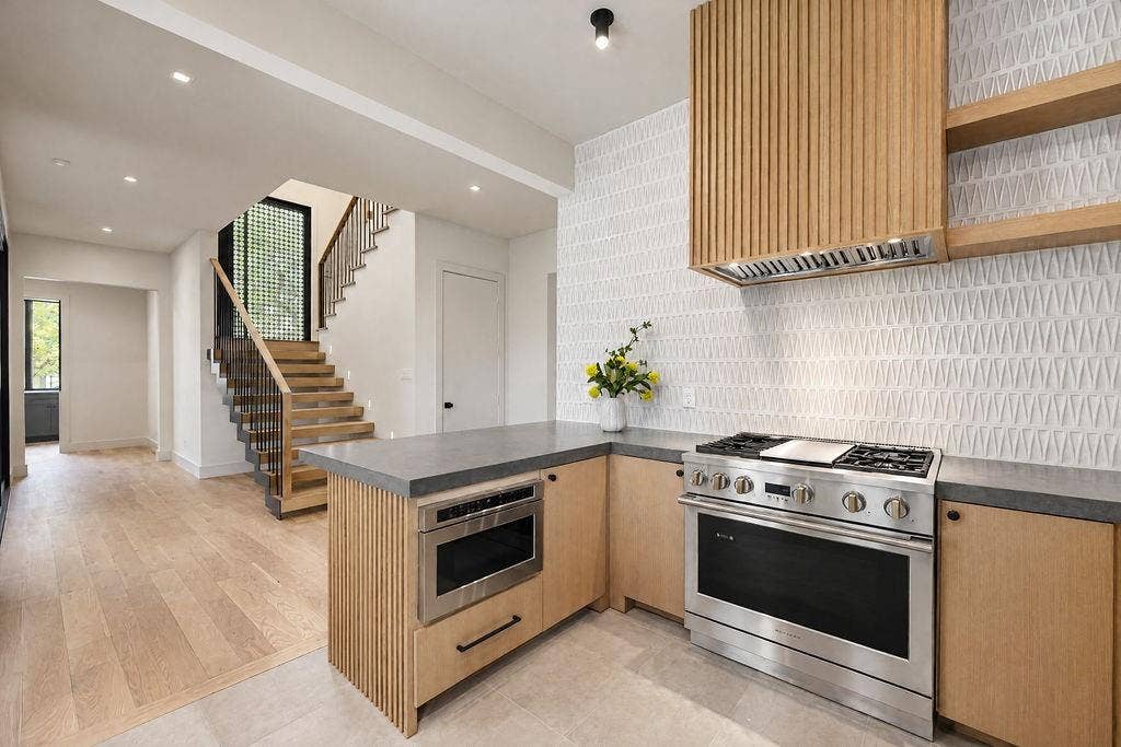 Savor simple weeknight cooking over the gas range, framed by custom wood cabinetry and stunning backsplash tile