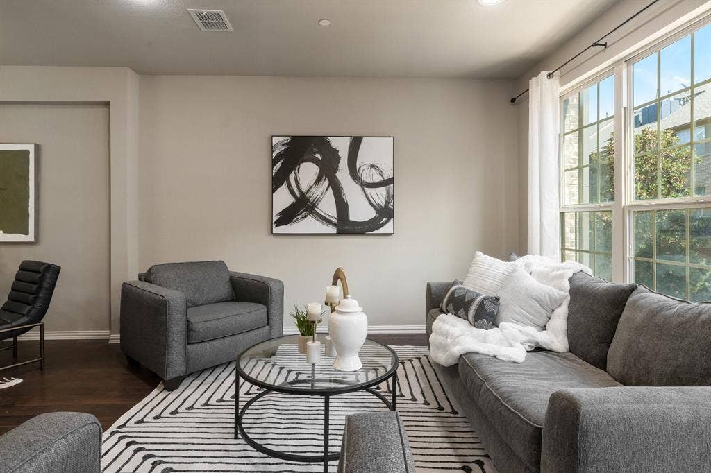 Wood-finish flooring, neutral wall tones, and large grid-pattern windows