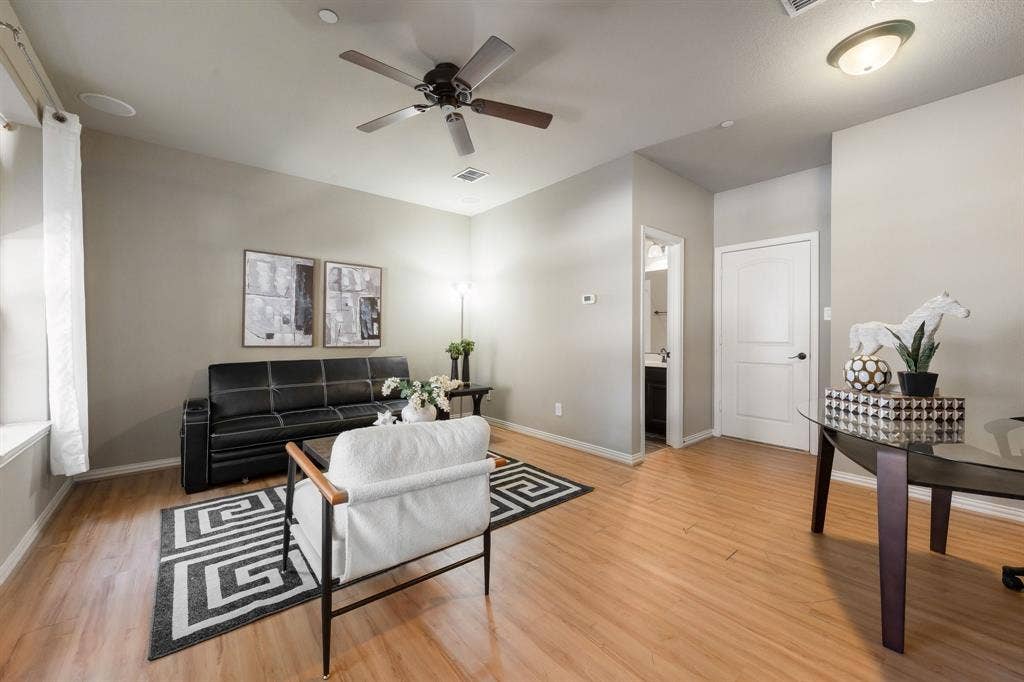 Room featuring wood-finish flooring, a ceiling fan, and a neutral color palette