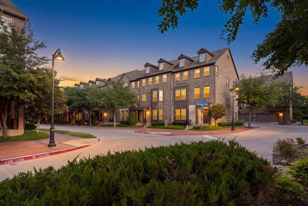 Multi-story brick exterior featuring dormer windows, bay architectural detailing, and recessed entryways
