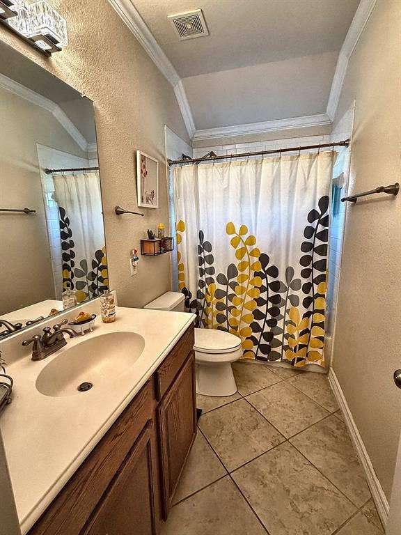416 Wooded Creek Avenue, Wylie, TX 75098 Bathroom featuring a wood-finish vanity with a molded countertop, oval integrated sink, metallic dual-handle faucet, vaulted ceiling, and diagonal-set tile flooring