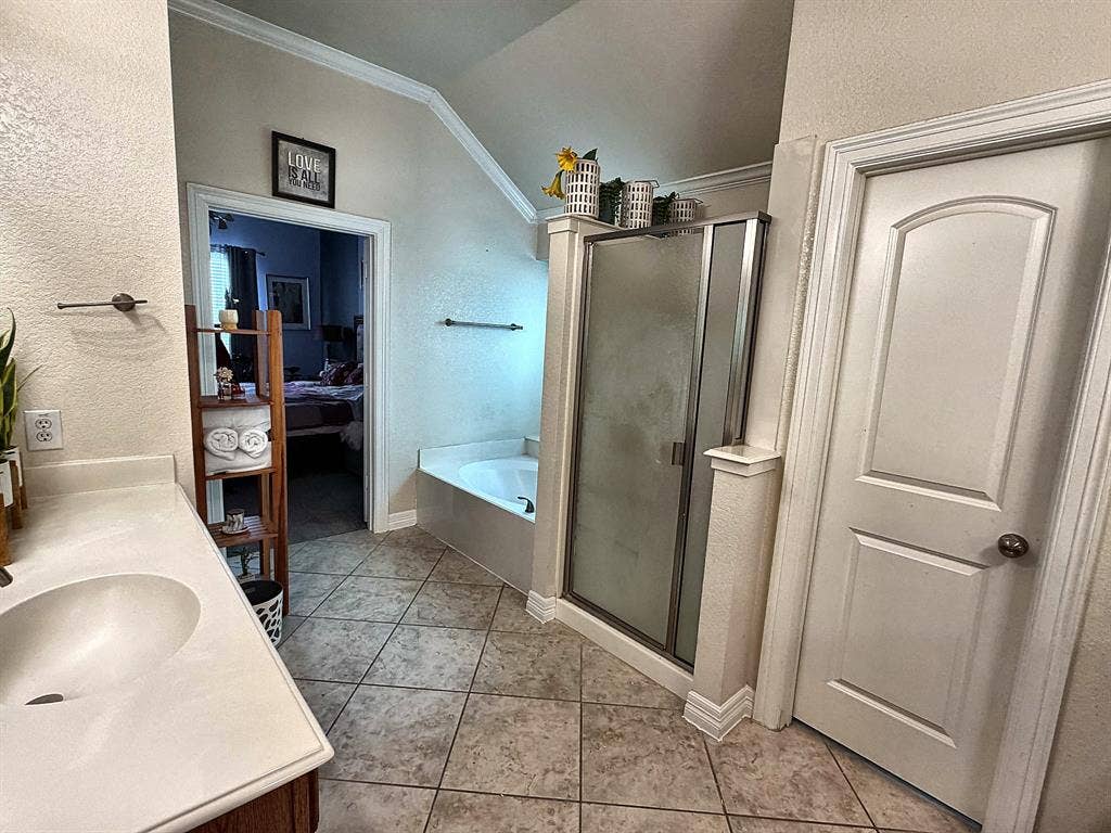 416 Wooded Creek Avenue, Wylie, TX 75098 Bathroom featuring a vanity with integrated sink, tiled flooring, soaking tub, and enclosed shower with metallic framing