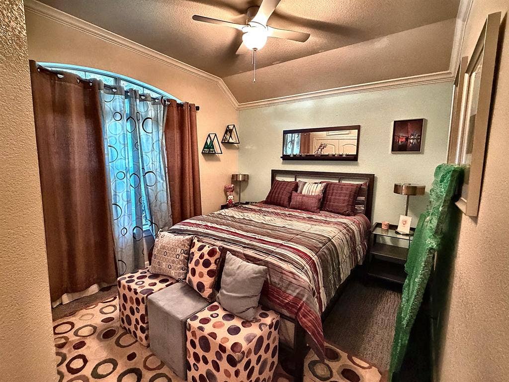 416 Wooded Creek Avenue, Wylie, TX 75098 Vaulted ceiling featuring crown molding, arched window, and a central ceiling fan with integrated lighting