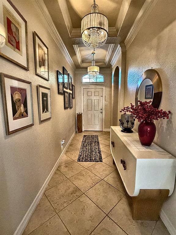 416 Wooded Creek Avenue, Wylie, TX 75098 Entryway featuring a coffered ceiling, dual tiered crystal chandeliers, neutral tile flooring laid on a diagonal, and a transom window above the front door