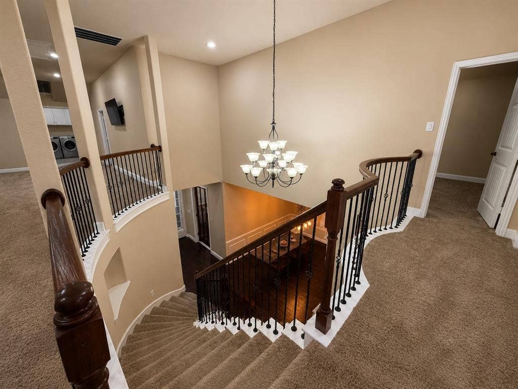 13812 Nash Lane, Frisco, TX 75035 Carpeted staircase with dark wood handrails and wrought iron balusters
