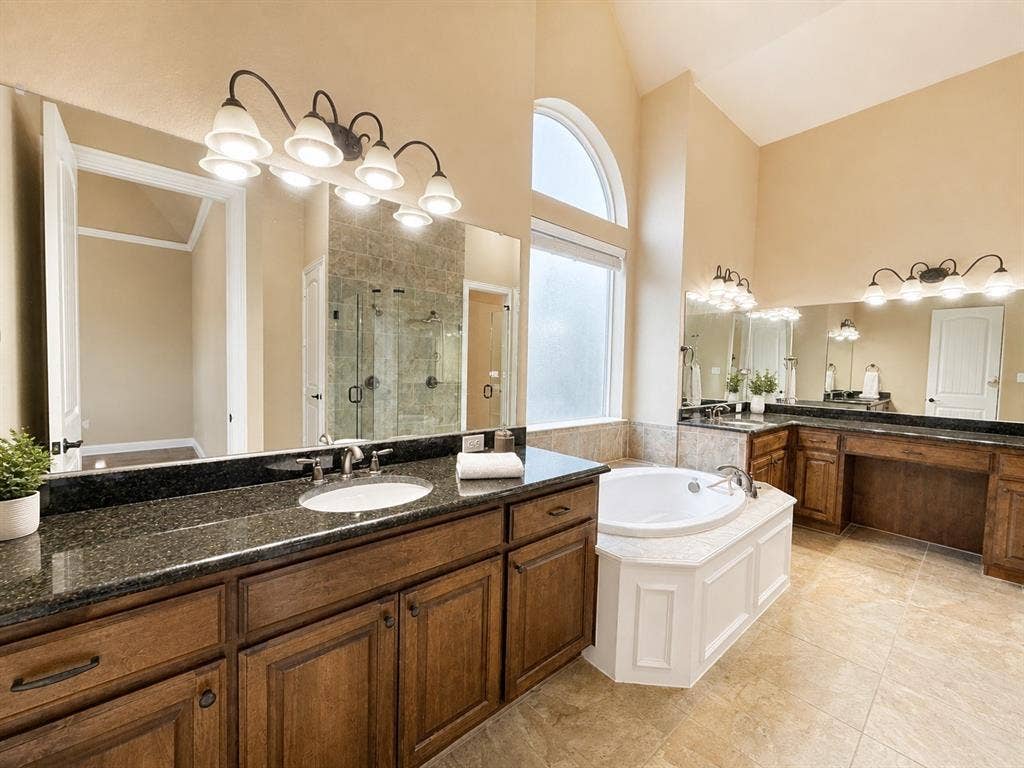 13812 Nash Lane, Frisco, TX 75035 Spacious bathroom featuring dual vanities with dark granite countertops and wood cabinetry
