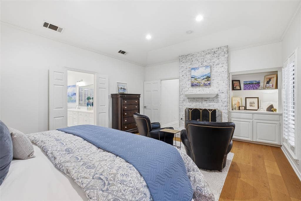 4115 Brooktree Lane, Dallas, TX 75287 A whitewashed brick fireplace and built-in cabinetry give the primary suite boutique-hotel style.