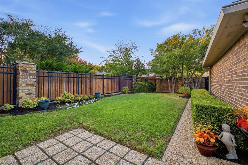 4115 Brooktree Lane, Dallas, TX 75287 Mature trees, landscaped beds, and a privacy fence make the yard feel like your own private park.