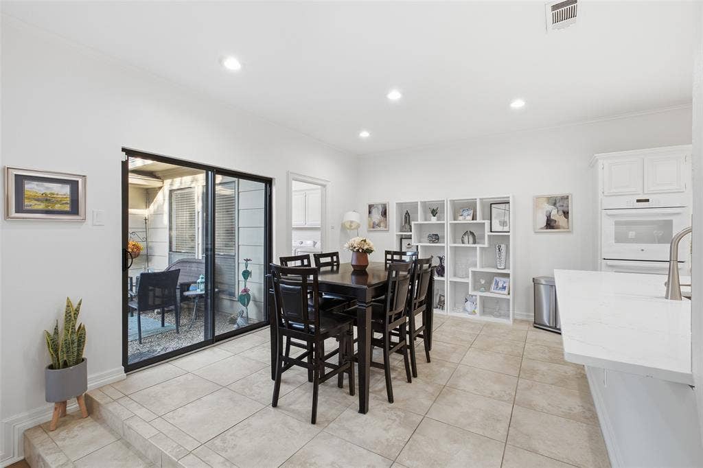 4115 Brooktree Lane, Dallas, TX 75287 Breakfast nook with built-in display shelving and a sliding door to the courtyard patio—morning coffee, al fresco.