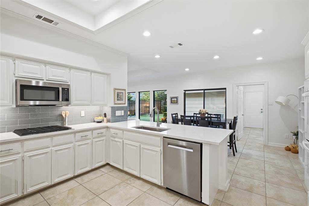 4115 Brooktree Lane, Dallas, TX 75287 Gas cooktop, stainless dishwasher and built-in microwave, plus views to the backyard while you cook.