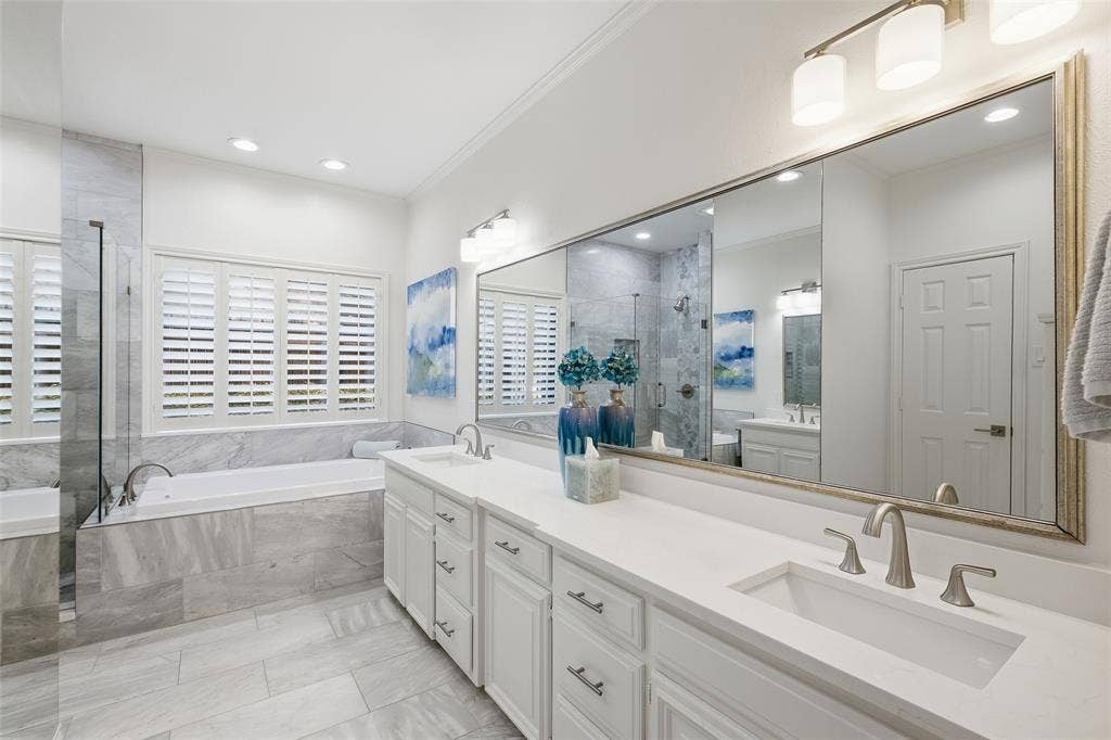 4115 Brooktree Lane, Dallas, TX 75287 Spa-inspired primary bath with dual sinks, quartz counters, a soaking tub, and frameless glass shower.