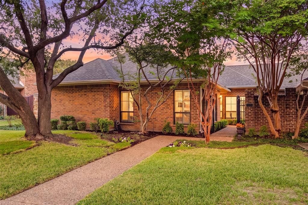 4115 Brooktree Lane, Dallas, TX 75287 Golden-hour curb appeal! Classic brick, mature shade trees, and a winding walk welcome you to this single-story half-duplex.