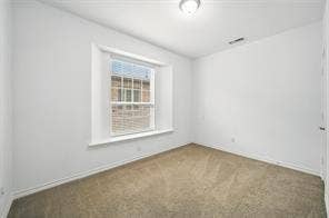 Room featuring neutral carpeting, crisp white walls, a bay window with a deep sill, and a recessed ceiling light fixture