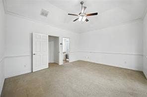 Vaulted ceiling, ceiling fan with light fixture, carpeted flooring, and wall molding