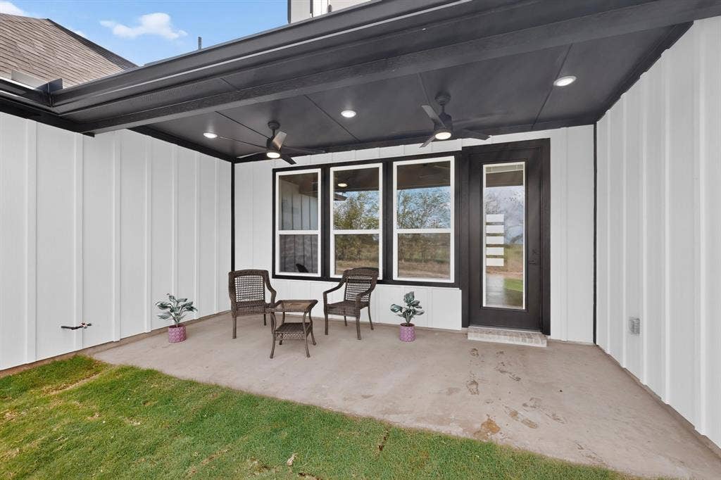 102 Nicklaus Drive, Sulphur Springs, TX 75482 Covered patio featuring a concrete surface, board-and-batten siding, dual ceiling fans, recessed lighting, and a single-light glass panel door