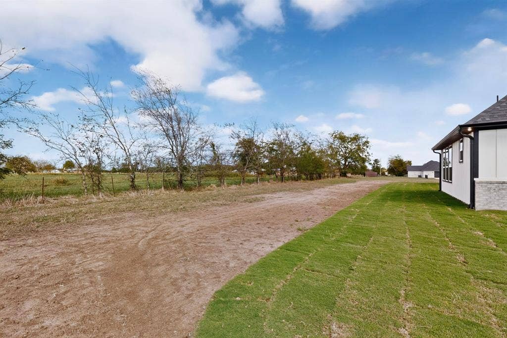 102 Nicklaus Drive, Sulphur Springs, TX 75482 Expansive outdoor space featuring a sodded lawn and natural perimeter trees