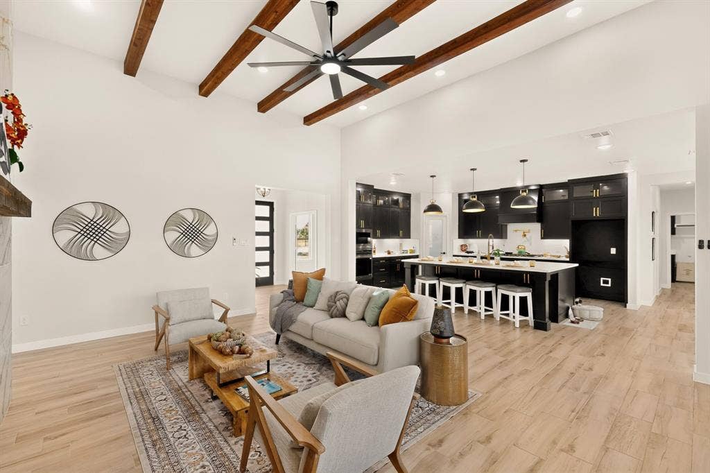 102 Nicklaus Drive, Sulphur Springs, TX 75482 Vaulted ceilings featuring exposed wood-finish beams, large-format ceiling fan, recessed lighting, wood-finish flooring, and kitchen with dark cabinetry and central island
