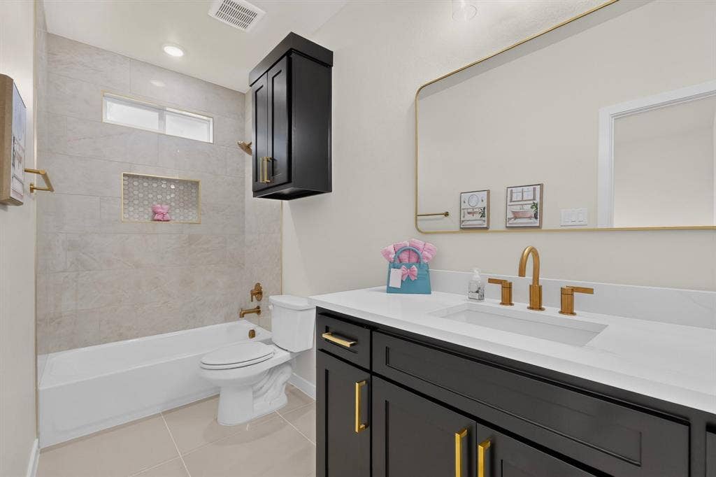 102 Nicklaus Drive, Sulphur Springs, TX 75482 Bathroom featuring a vanity with dark cabinetry, brass-tone hardware, and a solid-surface countertop