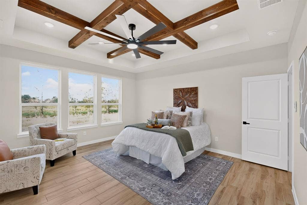 102 Nicklaus Drive, Sulphur Springs, TX 75482 Tray ceiling with decorative wood-finish beams, integrated recessed lighting, expansive multi-pane windows, and wood-finish flooring