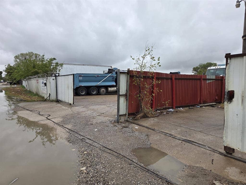 2311 Cartwright Street, Dallas, TX 75212 Industrial property featuring a gated entry, concrete paving, and perimeter metal fencing topped with security wire