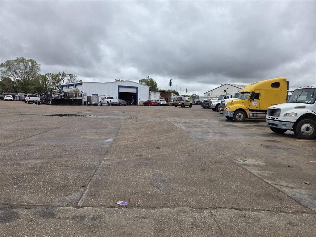 2311 Cartwright Street, Dallas, TX 75212 Industrial facility featuring a large concrete lot and high-clearance metal workshop building