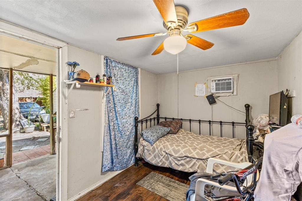 1801 Pleasant Run Road, Carrollton, TX 75006 Room featuring wood-finish flooring, a wall-mounted cooling unit, a ceiling fan with integrated lighting, and an installed wall-mounted shelf