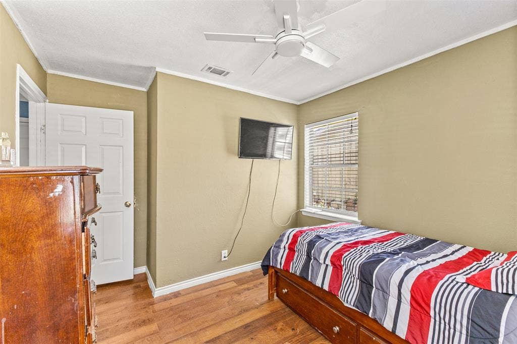 1801 Pleasant Run Road, Carrollton, TX 75006 Room featuring wood-finish flooring, a ceiling fan, and a single-pane window with horizontal blinds