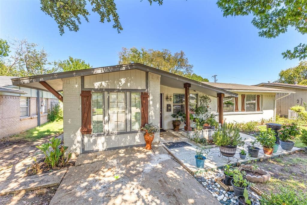 1801 Pleasant Run Road, Carrollton, TX 75006 Single-story exterior featuring painted brick facade, decorative wooden shutters, covered front entryway, and concrete patio
