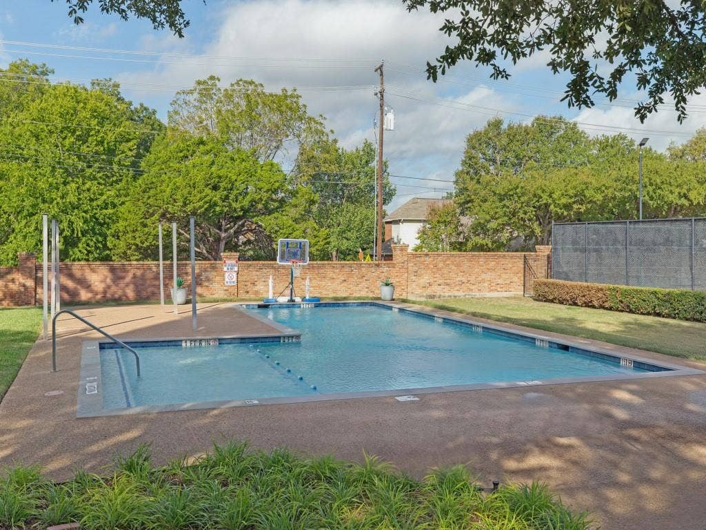 2817 Mayfair Lane, McKinney, TX 75071 Swimming pool with aggregate surround, brick perimeter wall, and manicured landscaping