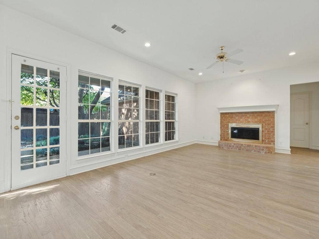 2817 Mayfair Lane, McKinney, TX 75071 Living space featuring wood-finish flooring, a brick fireplace with a mantle, recessed lighting, a ceiling fan, and multiple windows with a full-lite glass door