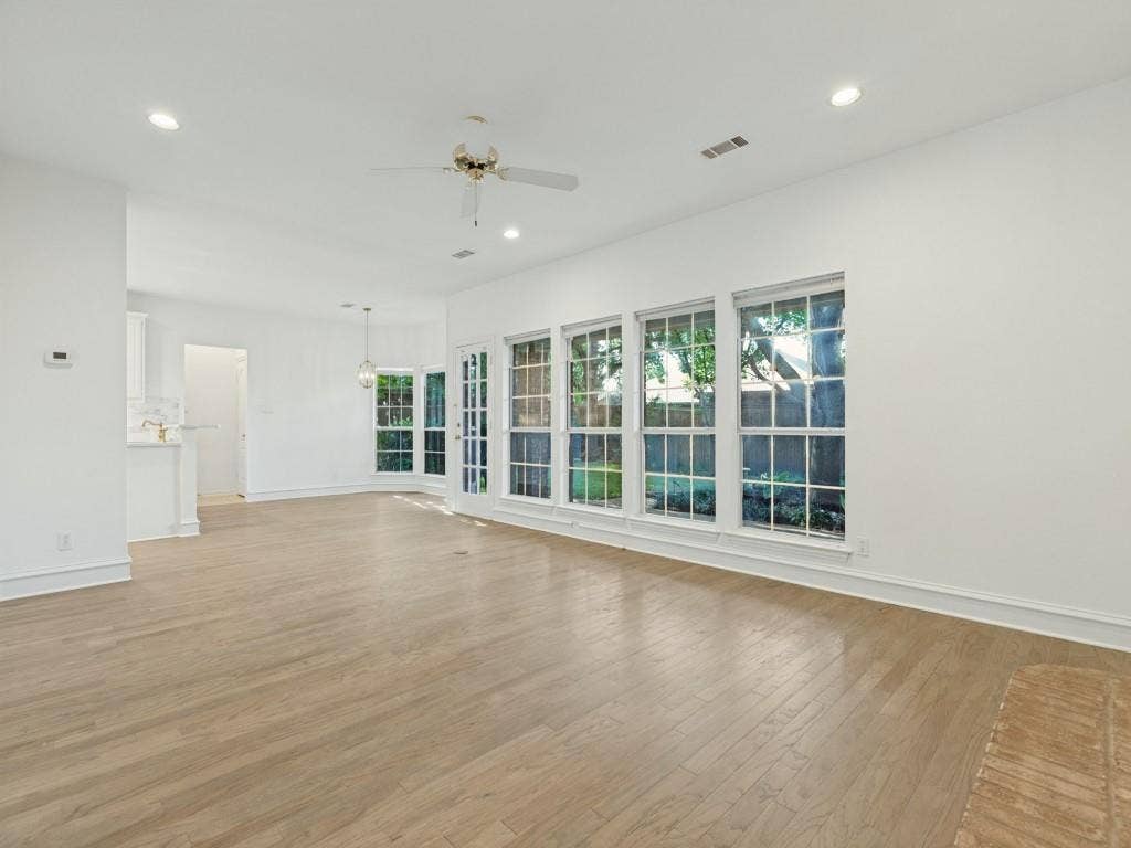 2817 Mayfair Lane, McKinney, TX 75071 Open interior space featuring wood-finish flooring, recessed lighting, ceiling fan, and large-paned windows