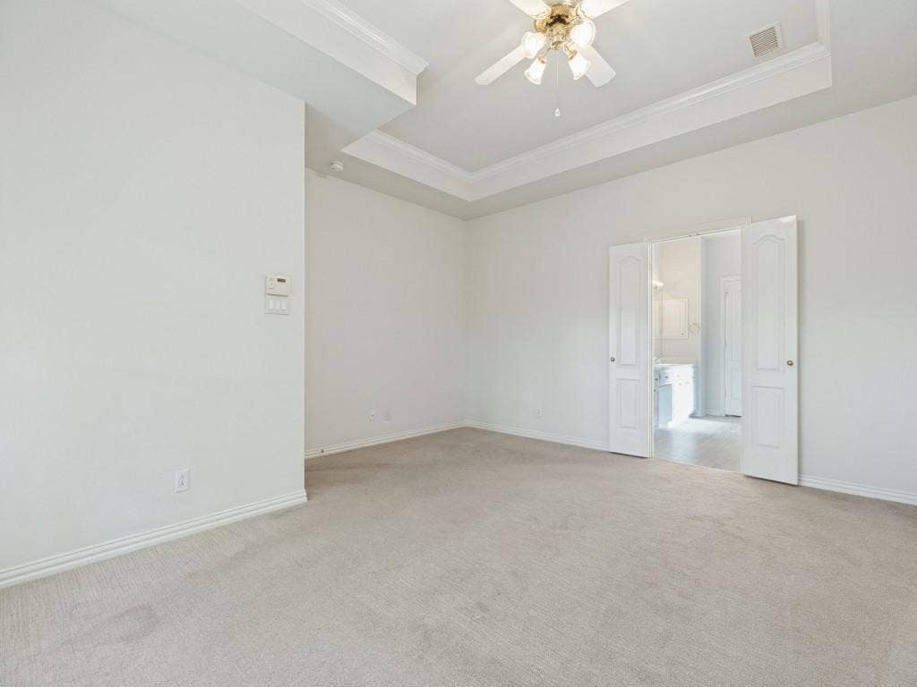 2817 Mayfair Lane, McKinney, TX 75071 Room featuring a tray ceiling, neutral carpeting, and a ceiling-mounted light fixture with fan