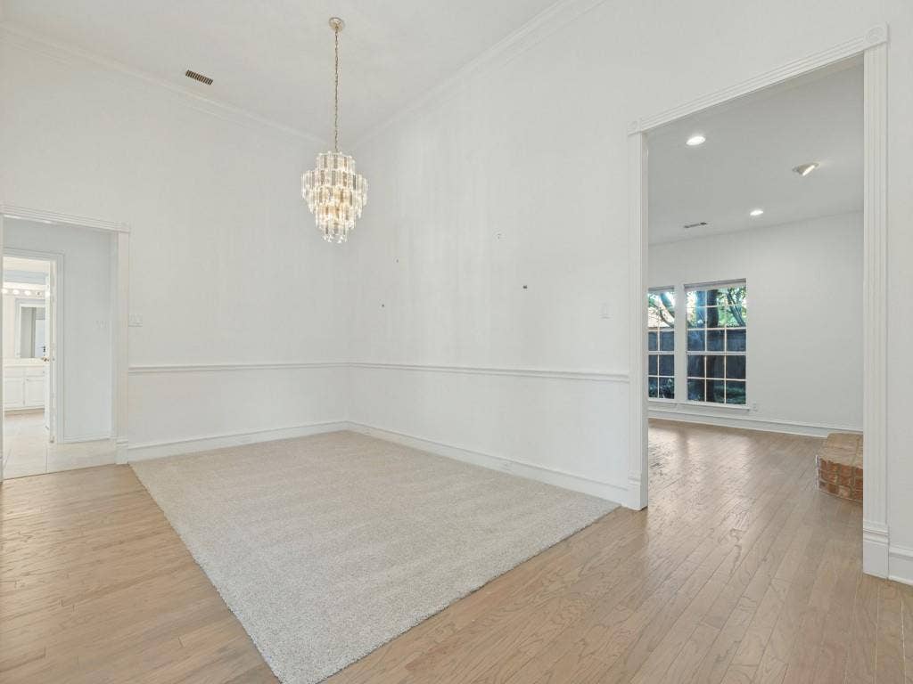 2817 Mayfair Lane, McKinney, TX 75071 High ceilings featuring a tiered crystal chandelier, chair rail molding, and wood-finish flooring