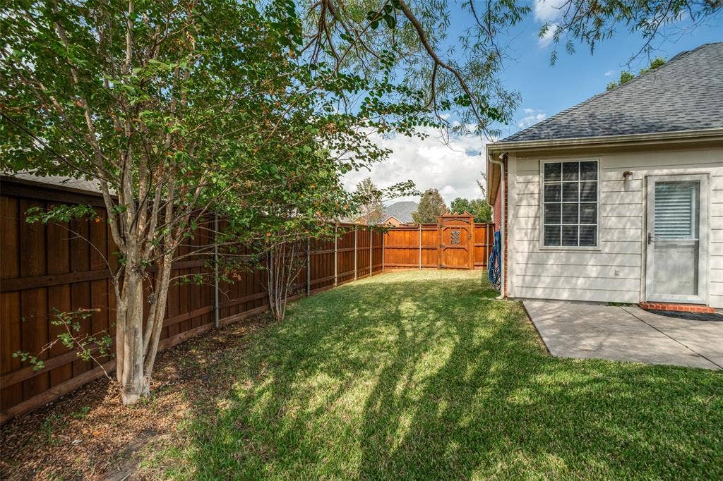 Side yard with lawn, mature trees and wood privacy fence