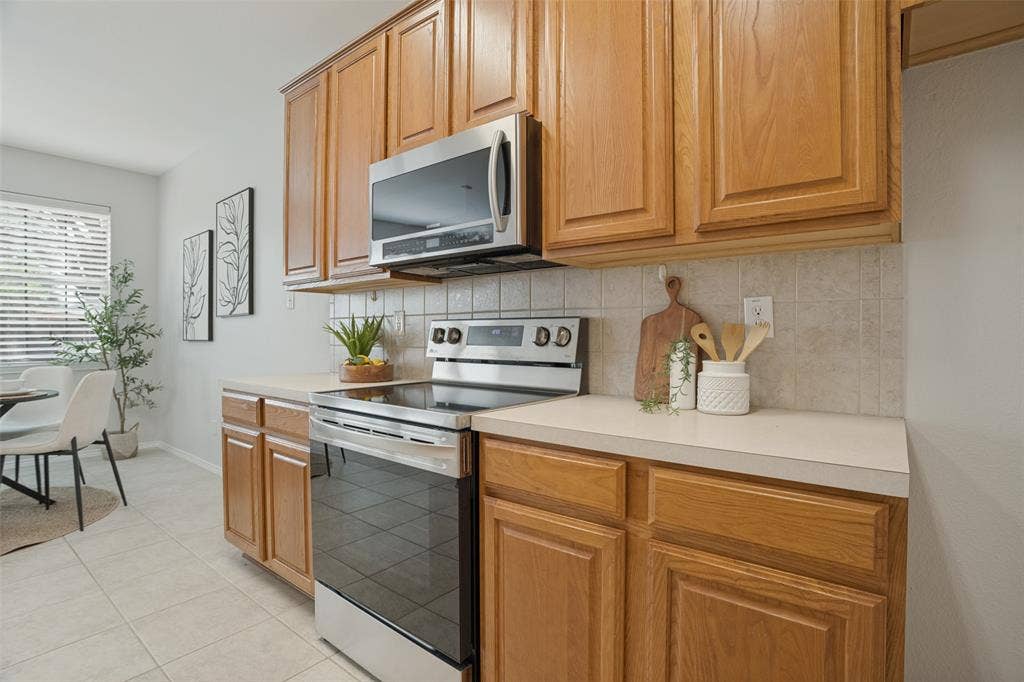 Stainless steel range and microwave with surrounding wood cabinetry