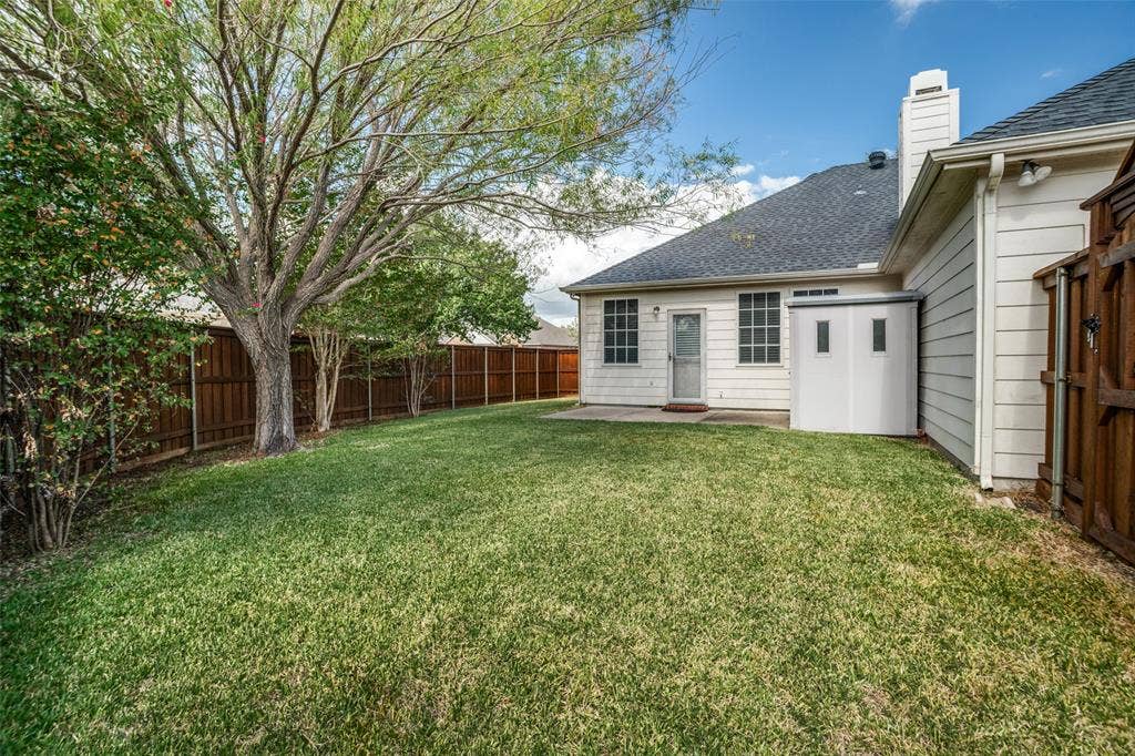 Fenced backyard with lawn, mature trees and established