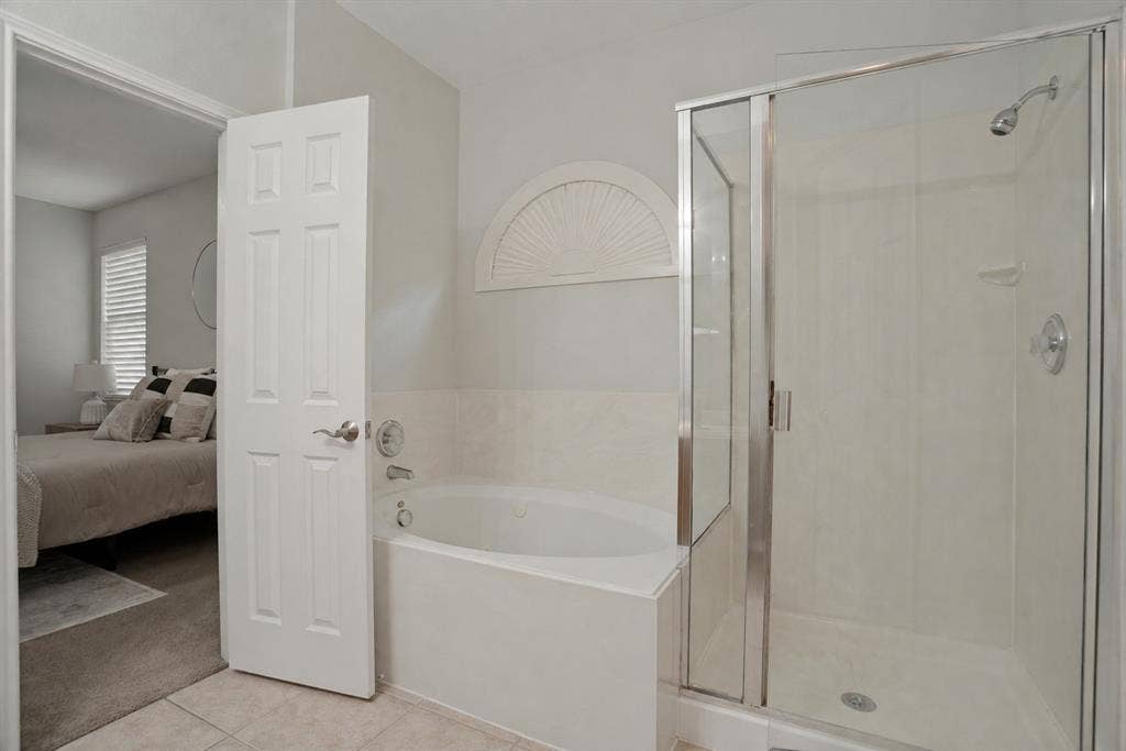 Primary bathroom with separate tub and glass-enclosed shower
